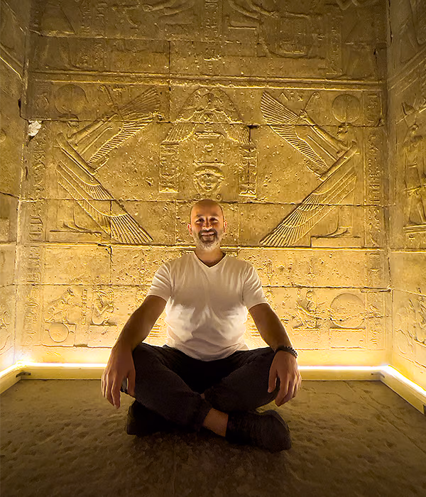 A man in meditation inside a golden stone chamber