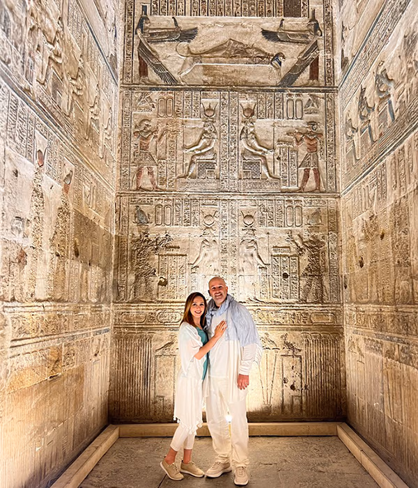 Two people standing together inside an ancient temple chamber